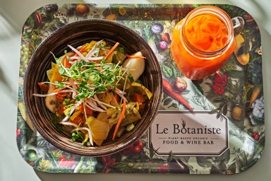 a tray with a le botaniste bowl and juice