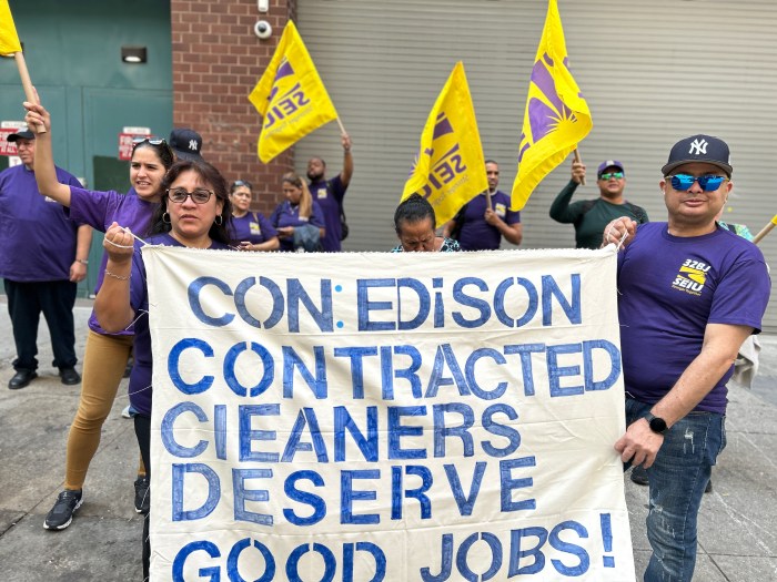 con ed workers rallying outside wearing purple shirts and holding signs