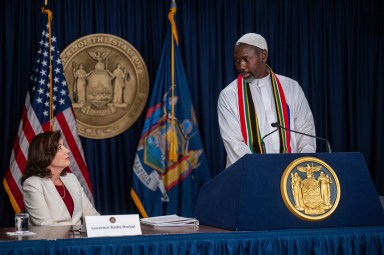 NYS Gov. Kathy Hochul with Sheikh Musa Drammeh at a podium