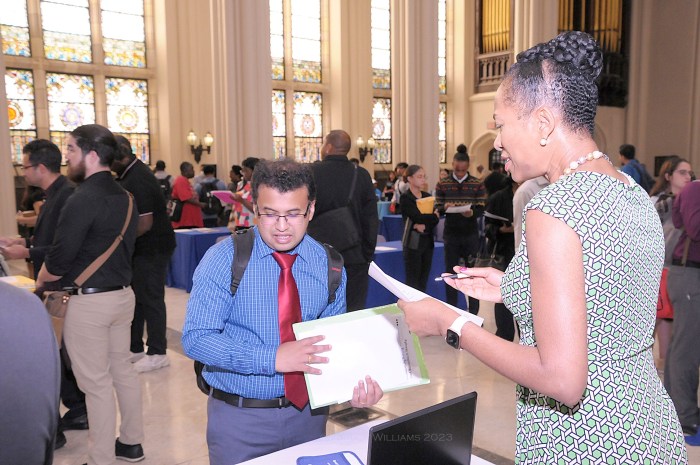 people around a table at in a hall at a job fair