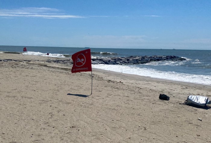 Beaches closed sign on Rockaway Beach