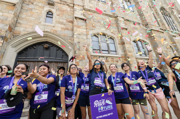 teenagers wearing purple shirts as the participate in a run