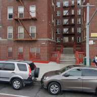 apartment building with cars parked in front in the Bronx