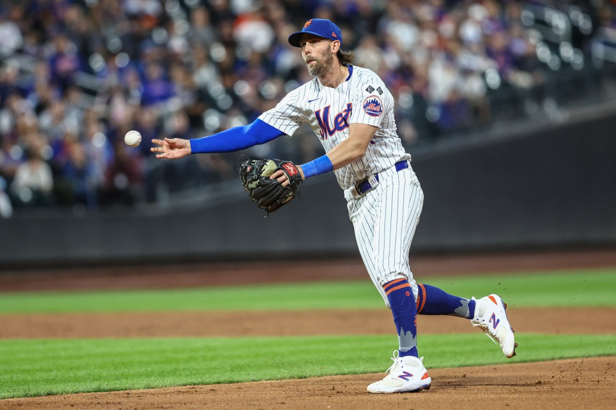 Mets second baseman Jeff McNeil throws to first base.