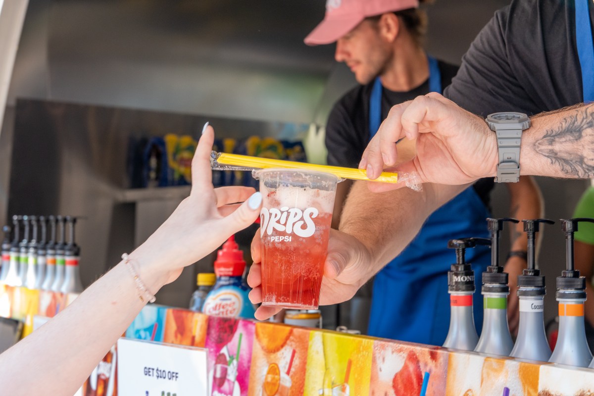 a cup of drips by pepsi being handed to a customer