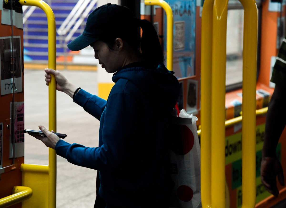 42nd Street subway rider looks at cellphone during 5G service