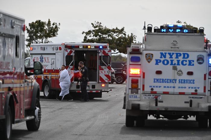 Paramedics tend to a fisherman who rescued a man from the Canarsie Pier.