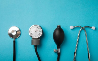 Black blood pressure monitor on a blue background. Medical equipment blood pressure monitor. Healthcare. Place for text. Medicine concept. Cardiology concept.