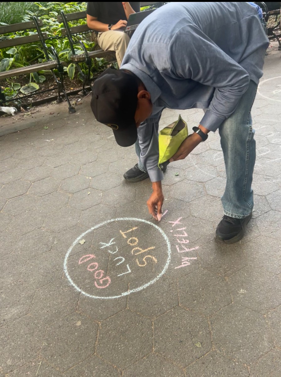 Felix Morelo drawing a good luck spot in Washington Square Park.