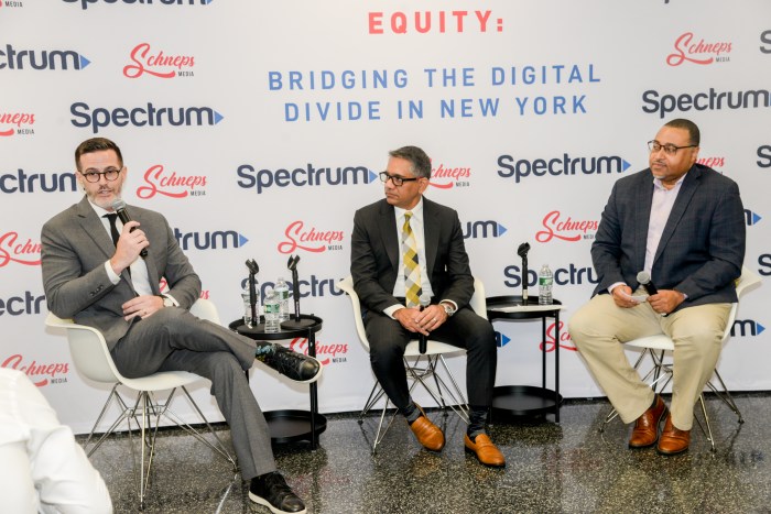 three men on a panel discussing the digital divide in NYC