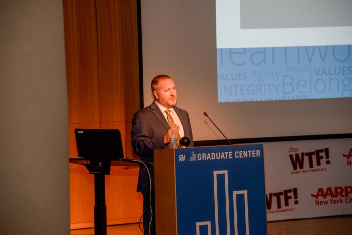 man in a suit at a podium on stage