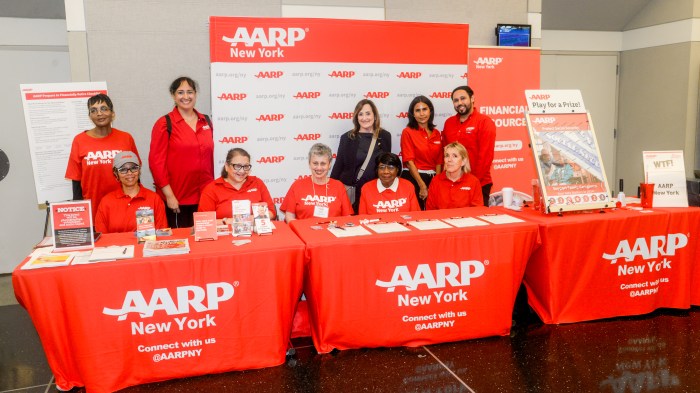 people at a table with AARP logos and papers on it