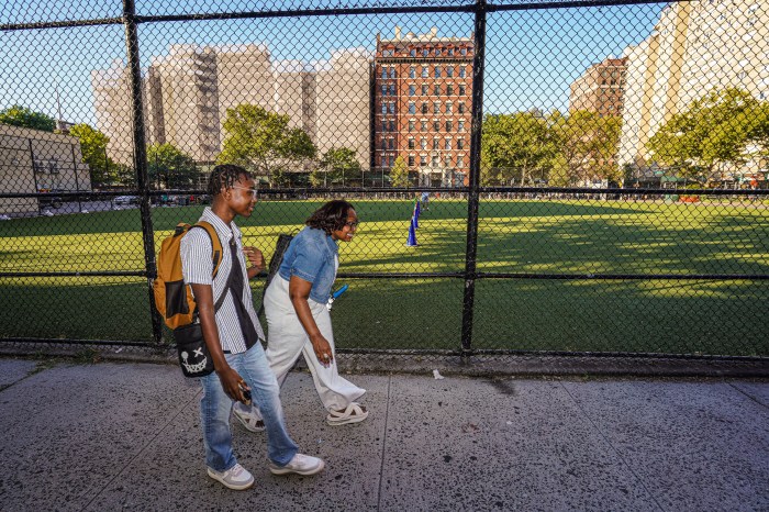 two people walking on sidewalk