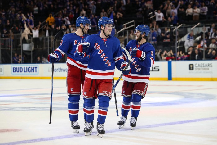 New York Rangers left wing Alexis Lafreniere (13) celebrates a goal by New York Rangers center Adam Edstrom (not pictured) with defenseman Jacob Trouba (8) and defenseman Zac Jones (6) during the third period against the New York Islanders at Madison Square Garden.