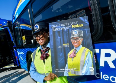 MTA transit worker shows off ad campaign poster