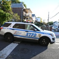 Queens police vehicle outside scene where man was shot dead