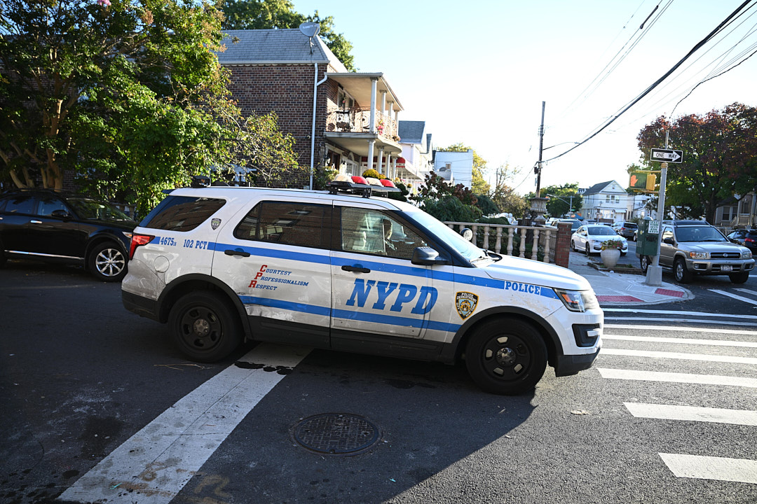 Queens police vehicle outside scene where man was shot dead