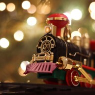 Photo of toy train, concept holiday delivery , soft defocused. Christmas lights illumination.