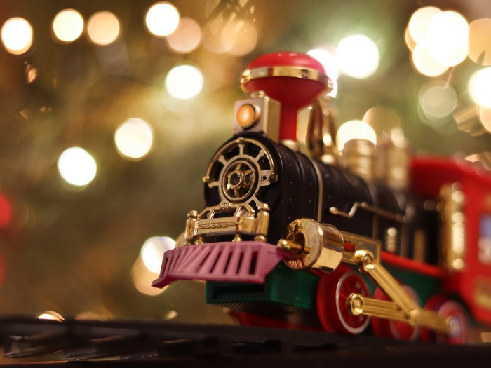 Photo of toy train, concept holiday delivery , soft defocused. Christmas lights illumination.