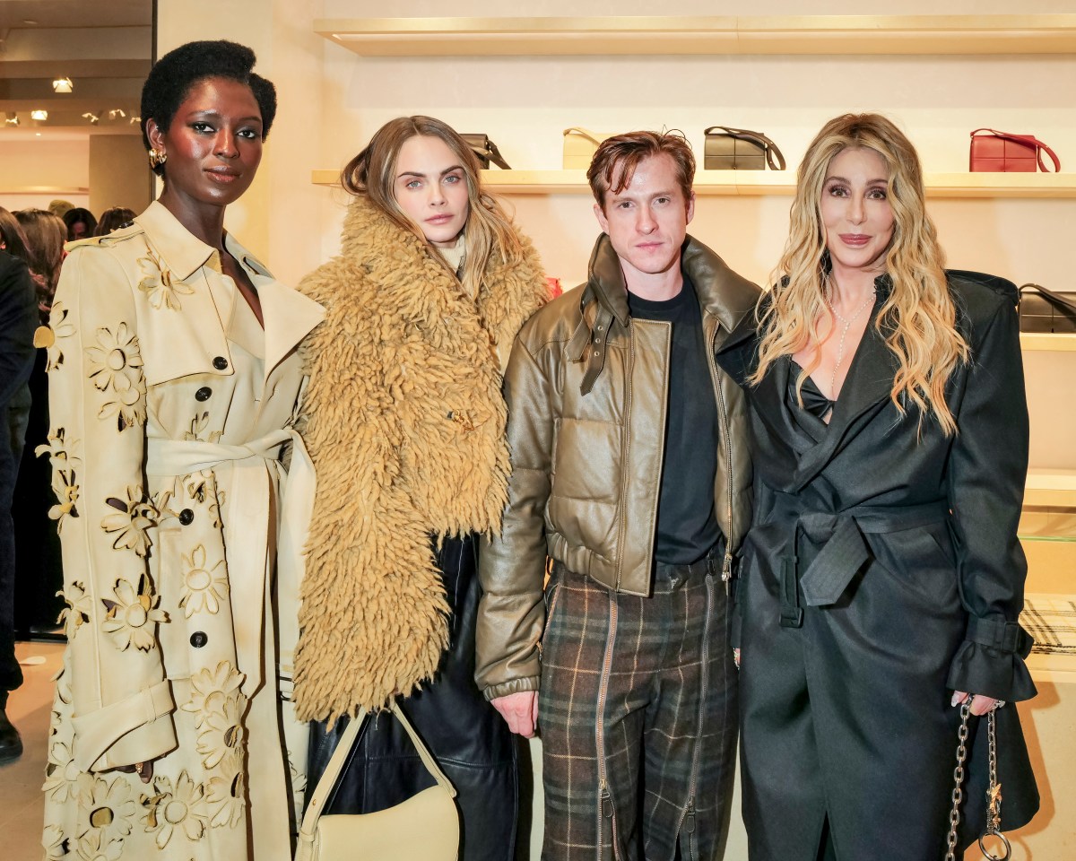 four people at a reopened Burberry flagship store in Midtown