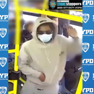 person wearing light colored clothes and a mask on a Bronx bus