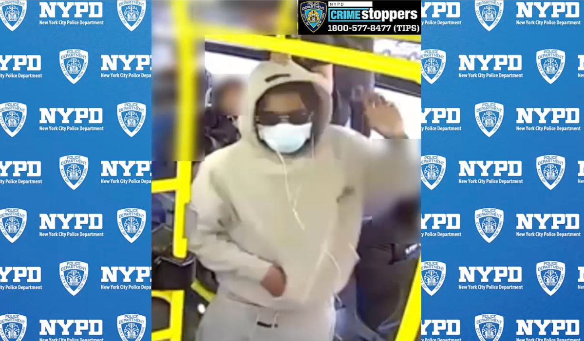 person wearing light colored clothes and a mask on a Bronx bus