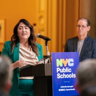 incoming NYC public schools chancellor Melissa Aviles-Ramos wearing a green jacket at a podium