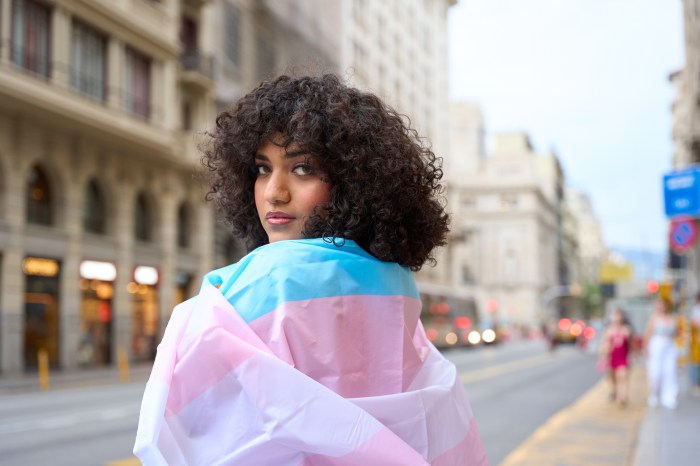 Horizontal photo with copy space of a transgender person wrapping with a transgender flag