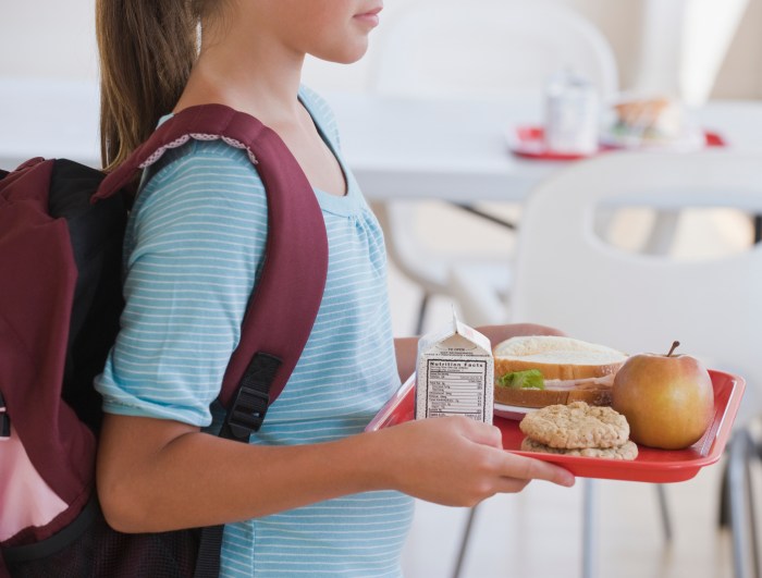 Girl carrying lunch tray at school