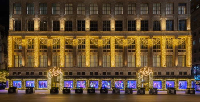 A far shot showing Saks window display lit up at night.