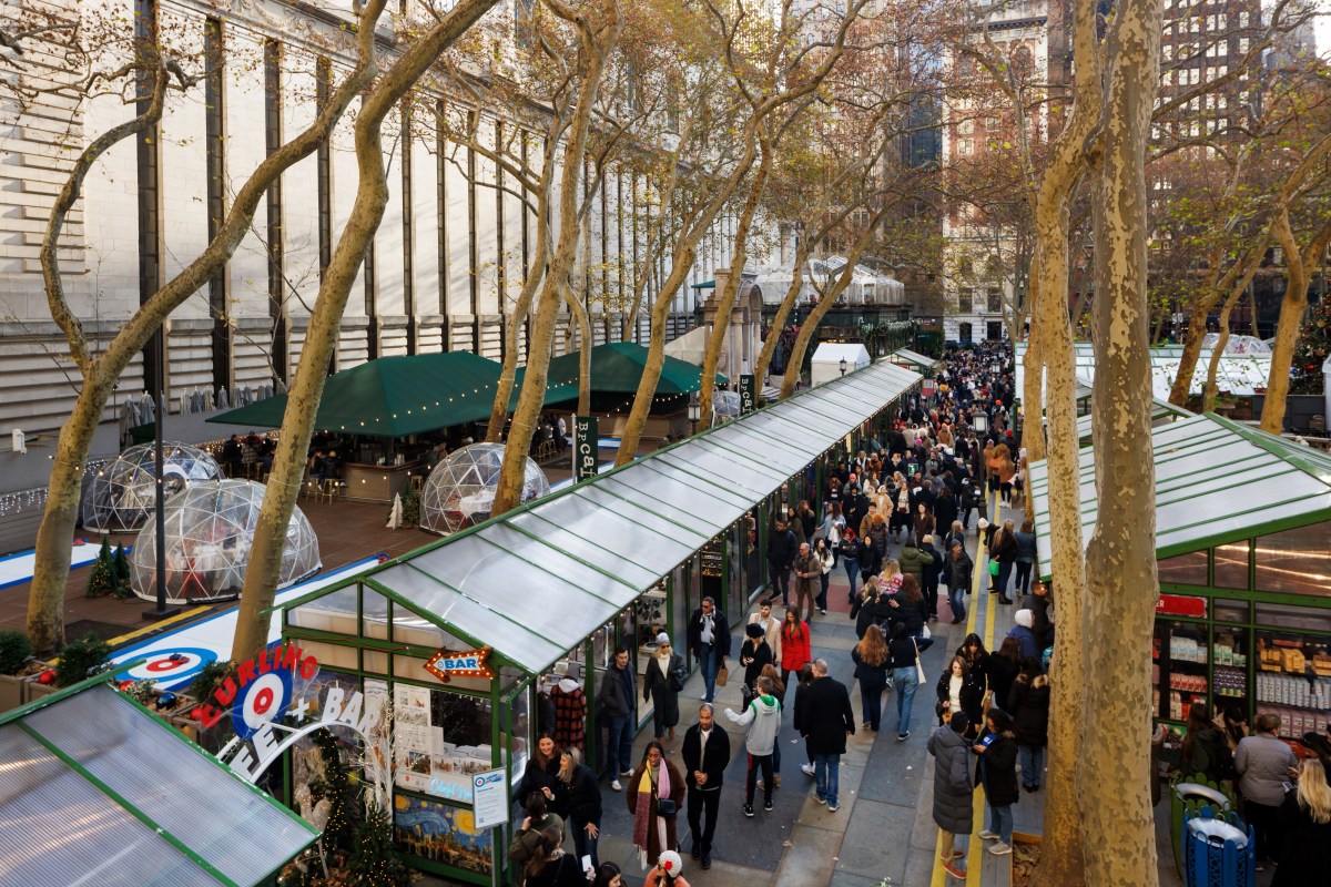 Holiday Shops and the Curling Cafe & Bar on the Upper Terrace at Bank of America Winter Village at Bryant Park NYC.