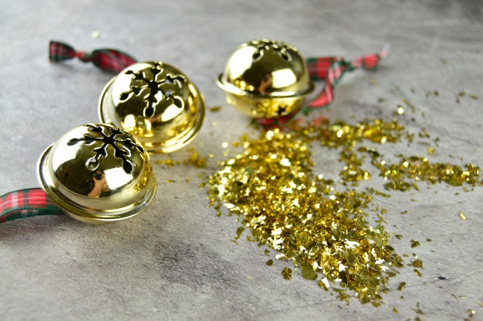 Golden jingle bell in a table with golden confetti, close-up