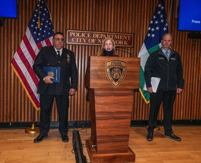 three people at a podium during a press conference about a homicide in Brooklyn