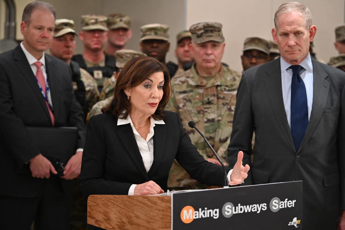 people at a podium during press conference about National Guard troops in NYC subways