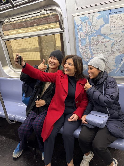 Governor Hochul takes a selfie with a pair of excited riders.