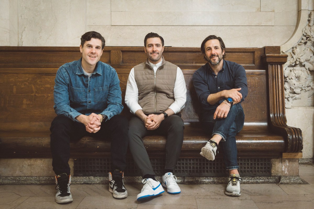 three men who own Zaro's Family Bakery sitting on a bench in a train station