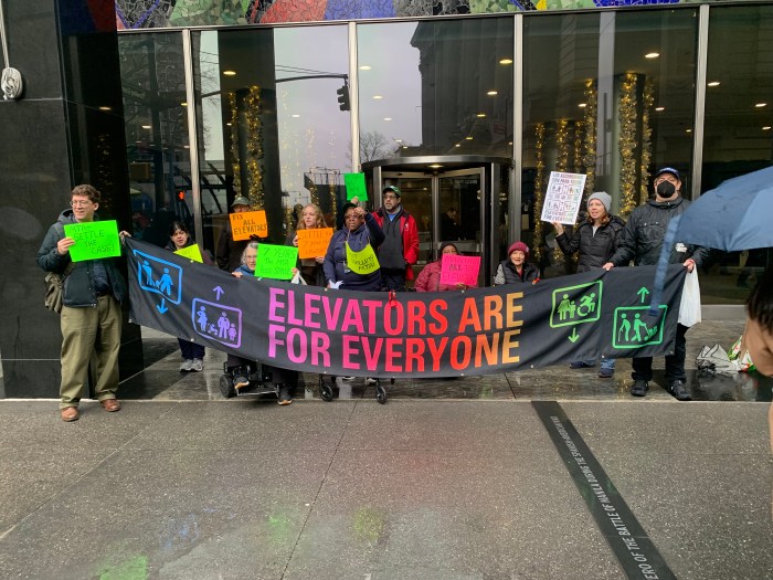 people outside a building advocating for more accessible subway stations in NYC