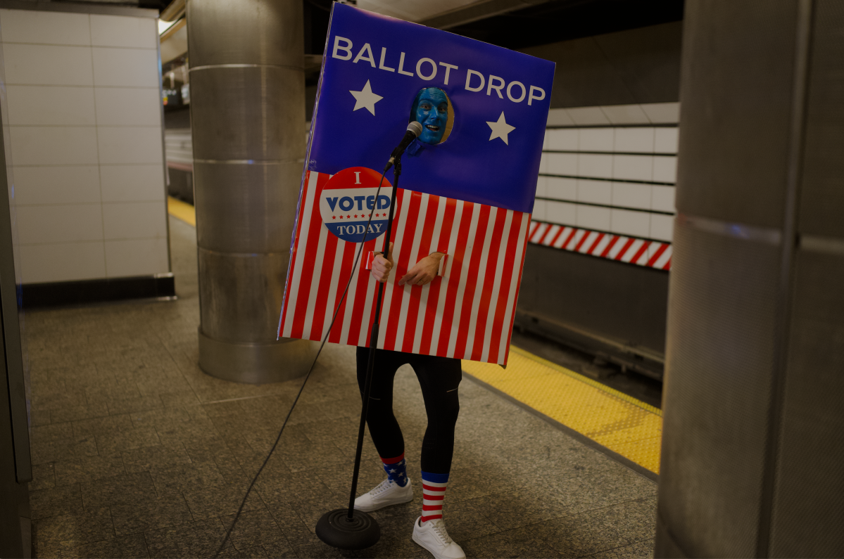 Comedian Marcus Monroe dressed as a ballot box on a NYC subway platform.