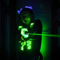 A little girl playing laser tag. Photographed at a high ISO under black light to capture true look and feel of game.