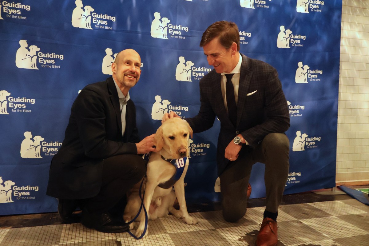 Guiding Eyes for the Blind CEO Thomas Panek (left) celebrated his one-year anniversary with his guide dog, Ten, with Eli Manning (right).