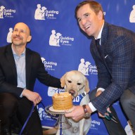 Guiding Eyes for the Blind CEO Thomas Panek (left) celebrated his one-year anniversary with his guide dog, Ten, with Eli Manning (right).