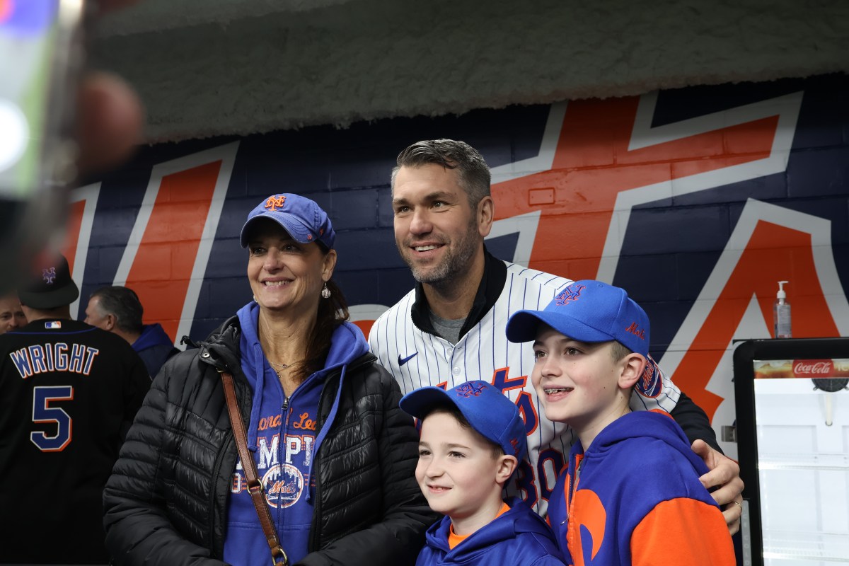 Mets player Josh Thole (center) takes a photo with three mets fans