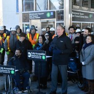 a group of people outside a Bronx subway station that was remodeled