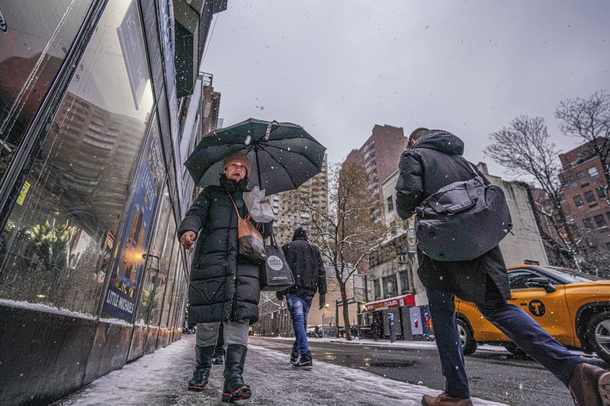 A women in snow fall holding umbrella