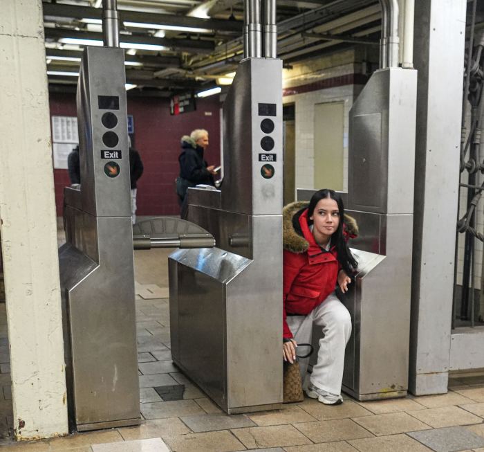 woman doing fare evasion through a turnstile