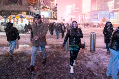 People walking through a snowy Times Square