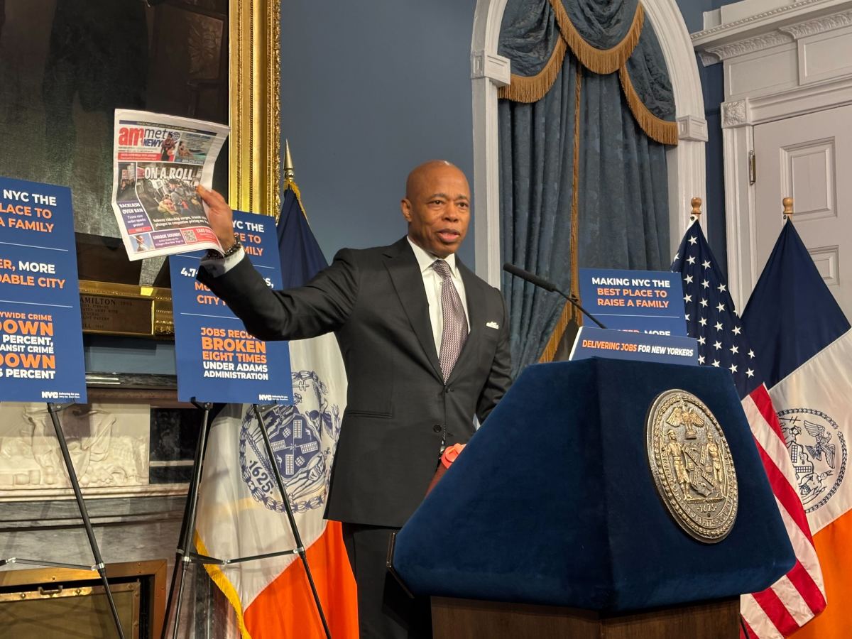 Mayor Adams holding up copy of amNewYork Metro