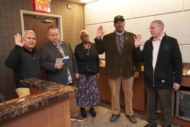 a group of people standing in a room, part of TWU Local 100