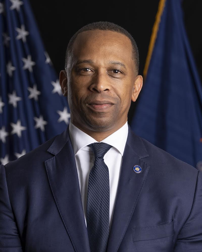 man in a suit in front of American flag