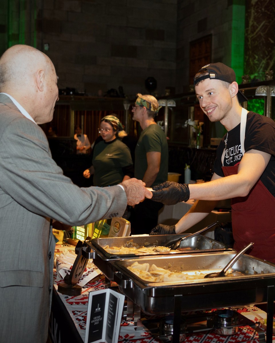 Person serving food at Grand Central Partnership's "Grand Gourmet" food show